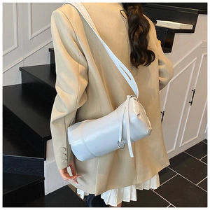 Detailed view of white cylindrical PU leather shoulder bag with metallic ring accessory
