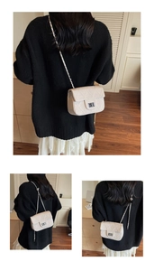 Detail of quilted leather crossbody bag featuring a classic silver rectangle metal turn-lock