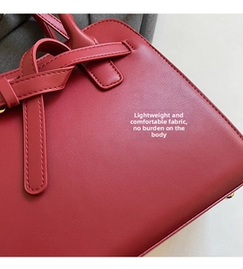 Macro shot of red leather handbag showing precise stitching and premium texture details