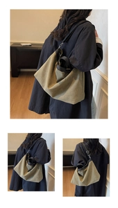 Detail view of large khaki canvas tote bag with black strap on model in home setting