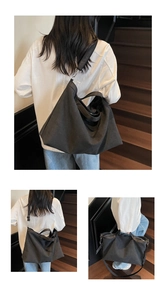 Detail of a black canvas tote bag showing wide fabric straps and metallic swivel hooks