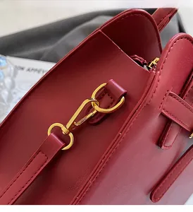 Close-up of luxury dark red leather handbag with gold metal hardware and fine stitching
