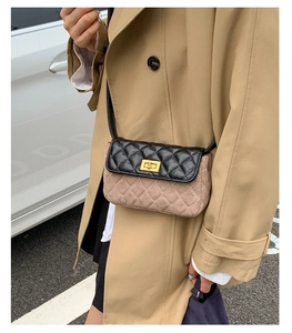 Detail of classic quilted crossbody bag with golden metal turn-lock and leather flap