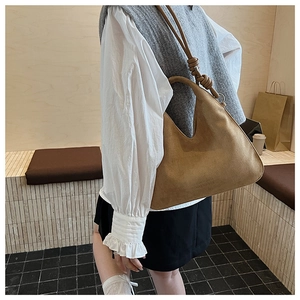 Detailed view of brown matte suede Hobo bag with unique shoulder strap knot and soft texture