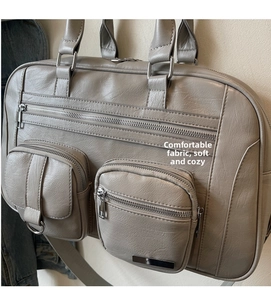 Dettaglio della borsa tote in tela grigia con doppie tasche zip e trama martellata