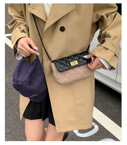 Detail of quilted flap bag with gold twist lock and black and khaki contrast design