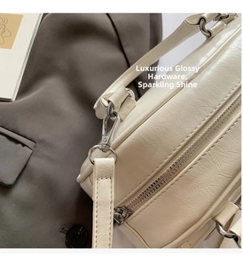 Close-up of cream white handbag featuring oil wax texture and silver hardware details