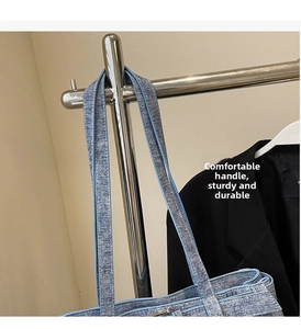 Close-up of blue denim tote bag reinforced wide handle and textured fabric detail