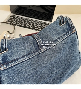 Détails d'un sac en denim bleu vintage avec coutures orange contrastées et anneau en métal