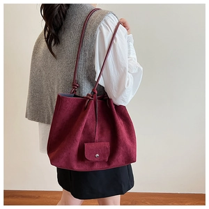 Detail of burgundy matte tote bag with shoulder tie and small matching pouch attachment
