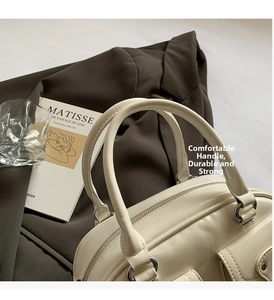 Detail of cream leather bowling bag with silver hardware and soft pebble texture