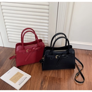 Detail shot of vintage leather square handbags in burgundy and black with buckle accents