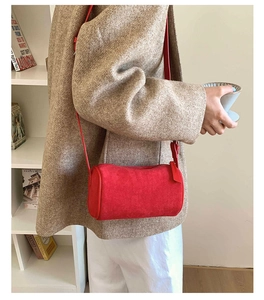 Macro detail of red frosted suede cylindrical crossbody bag with zip closure