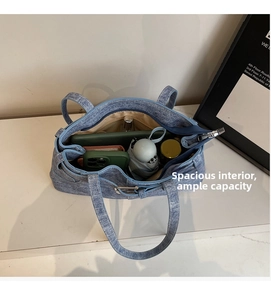 Detail view of the spacious light blue denim tote bag showing interior storage capacity