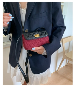 Close-up of quilted contrast crossbody bag with golden twist lock and thin strap