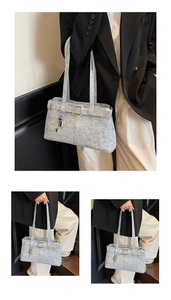Detail of blue denim shoulder bag featuring belt buckle decor and key pendant