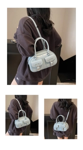Close-up of mint blue Boston bag with dual front utility pockets and metal buckles