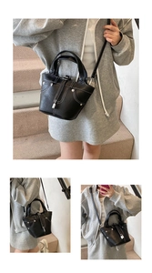 Détail du sac seau noir grainé avec surpiqûres blanches et design de poche en denim unique