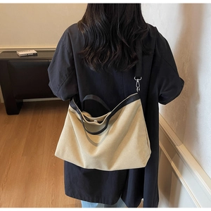 Detail of canvas tote bag with contrast black webbing handles and adjustable shoulder strap