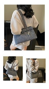 Detail view of denim shoulder bag with silver buckles and a key-shaped pendant charm