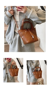 Détail du sac seau en cuir marron avec cadenas argenté et bandoulière amovible