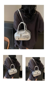 Close-up of metallic silver mirror finish and buckle pocket details on shoulder bag