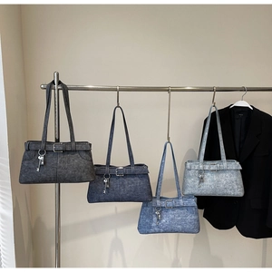 Denim tote bags in four colors with key charms and belt buckle details on metal hangers