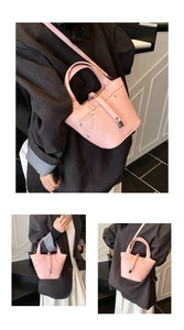 Détail du sac seau rose texturé avec boucle métallique et bandoulière en cuir élégante