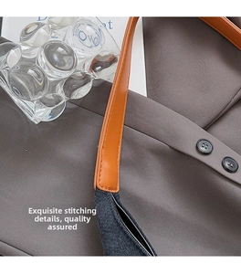 Detailed close-up of brown leather strap with fine stitching on nylon shoulder bag