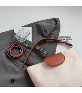 Flat lay of cream canvas shoulder bag with brown leather flap and GLEANER logo