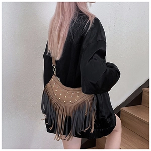 Detail of bohemian brown crossbody bag featuring stylish rivets and long layered tassels