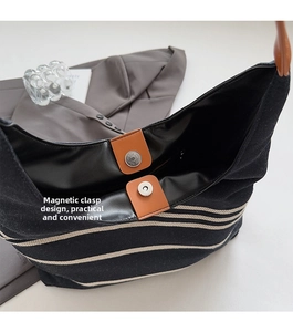 Detail view of large nylon shoulder bag with brown leather magnetic buckle closure