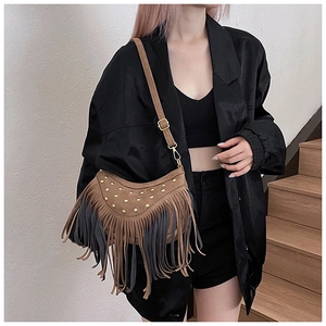 Detail of vintage suede hobo bag featuring metallic rivets and long bicolor tassels
