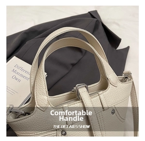 Gros plan sur un sac à main en cuir grainé avec doubles poignées et coutures précises