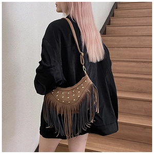 Detail showing vintage suede tassel shoulder bag with golden rivets and dual-tone fringes