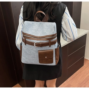 Detail of vintage canvas and leather backpack with brown pockets and buckle accents