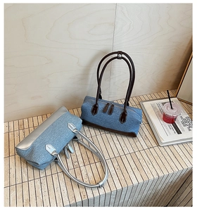 Photo lifestyle de sacs boston en denim vintage avec finitions cuir bleu et gris
