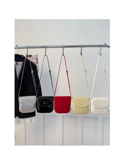 Série de sacs selle brillants déclinés en cinq couleurs sur un présentoir de mode