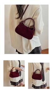 Detail van bordeauxrode fluwelen handtas met geknoopte handgreep en leren riem