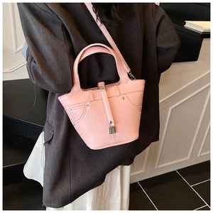 Détail du sac seau rose motif litchi avec cadenas argenté et rivets métalliques