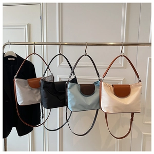 Group of casual nylon crossbody bags in grey, black, blue, and off-white colors