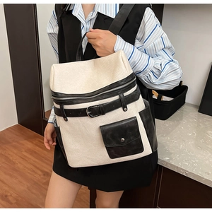 Detail of cream and black leather backpack with flap pocket and decorative buckle