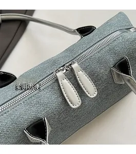 Detail of gray woven texture boston bag showing smooth double silver metal zippers