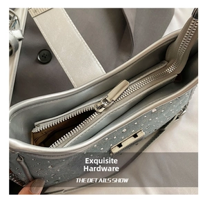 Macro shot of silver rhinestone handbag showing smooth metal zipper and gray inner lining