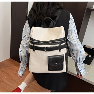Detail of a modern black and white commuter backpack with metallic buckle and pocket