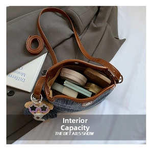Internal capacity of denim bucket bag showing phone, makeup and cute bear pendant
