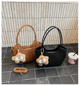 Détail de sacs tissés marron et noir avec pendentifs en étoile en peluche et sangle