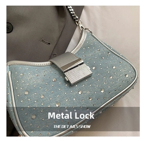Detail of denim bag with rhinestones, silver hardware lock and metal chain strap