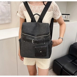 Detail of high-capacity commuter backpack featuring a unique leather belt and metal buckle