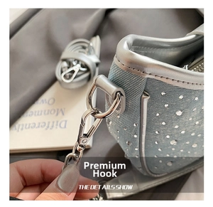 Macro shot of blue denim fabric with sparkling rhinestones and silver hardware hook detail